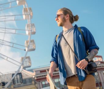 Handsome young man in casual clothing holding map