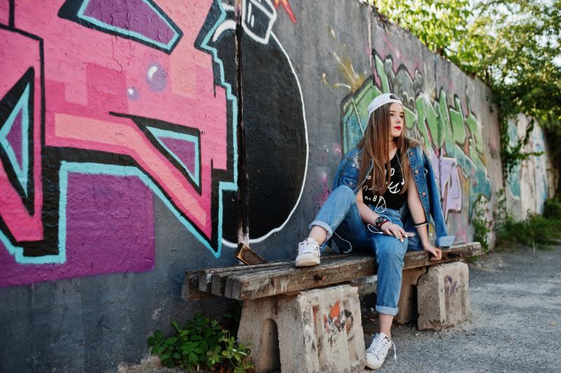 Woman sitting next to the Lennon Wall in Prague