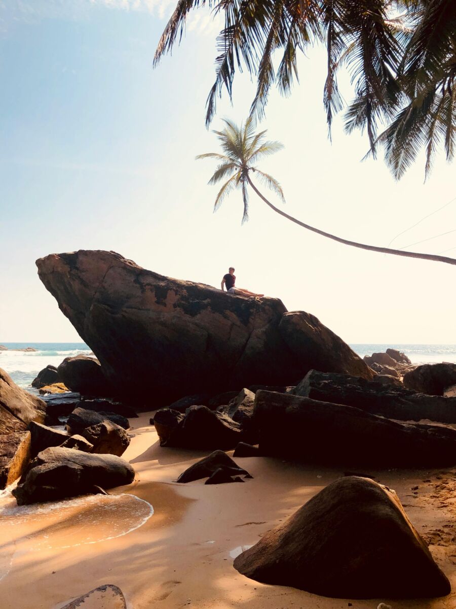 Man standing among rocks in Unawatuna, Sri Lanka