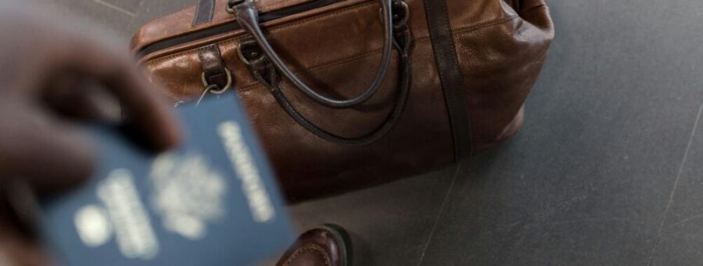 Traveler with passport and duffel bag