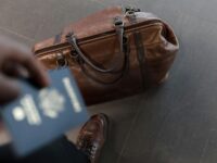 Traveler with passport and duffel bag