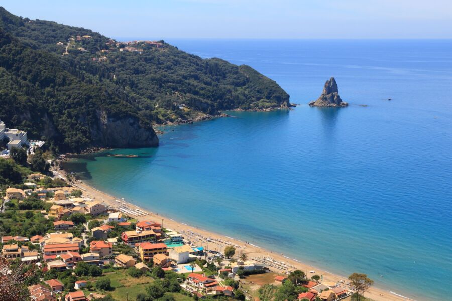 Aerial view of Agios Gordios, showcasing its stunning coastline and vibrant green hills on the island of Corfu