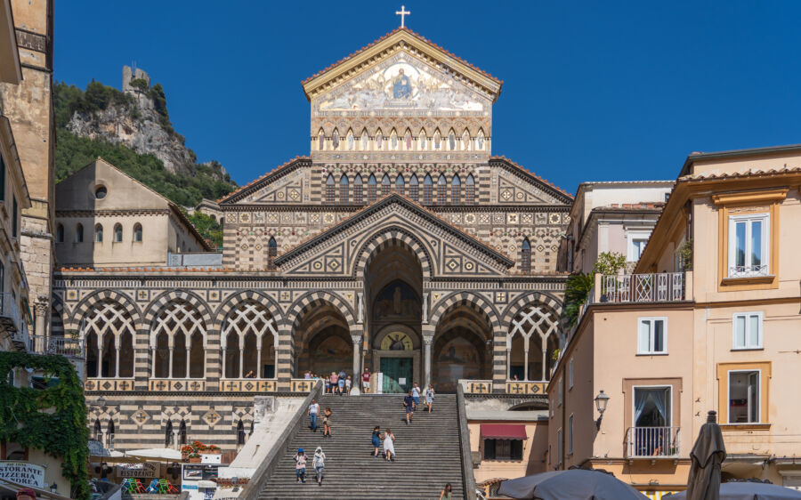 Visitors stroll up the steps of Amalfi Cathedral in Positano, Italy, enjoying the summer