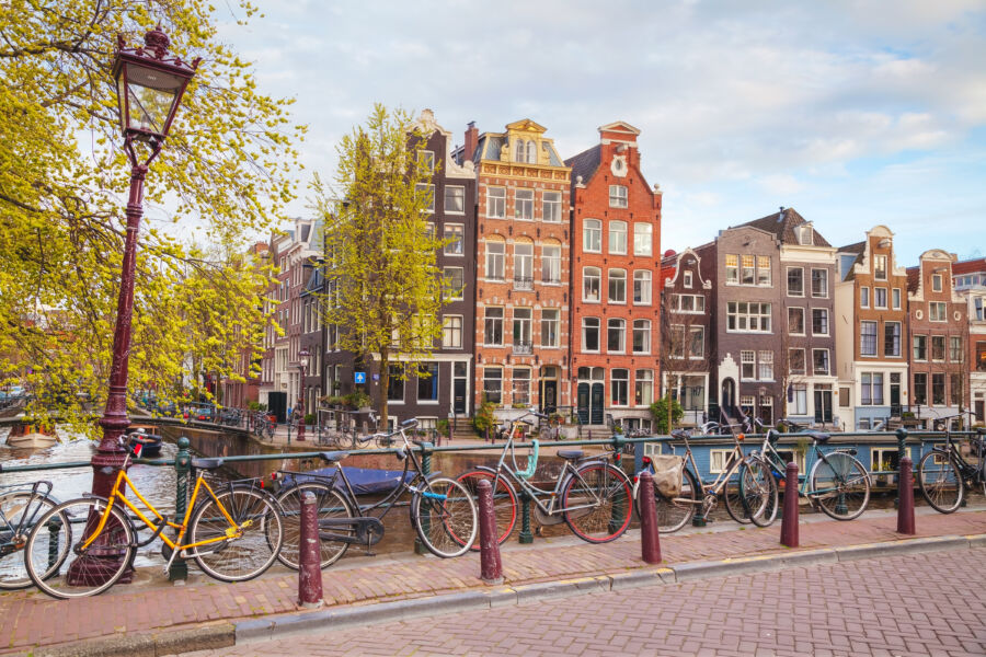 Bicycles lined up on a bridge in Amsterdam, showcasing the city's vibrant cycling culture and picturesque scenery