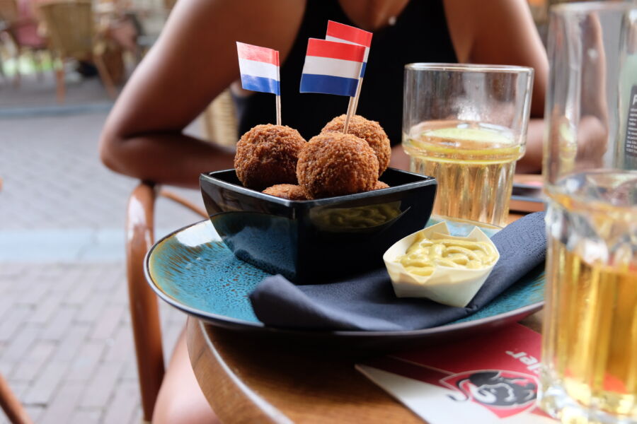 Bitterballen served with dip and drinks, featuring the Amsterdam flag prominently displayed