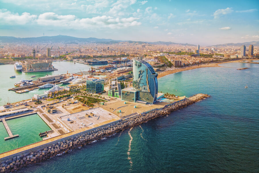 Panoramic aerial image of Barcelona, featuring the city skyline alongside the beautiful beach, capturing Spain's coastal charm