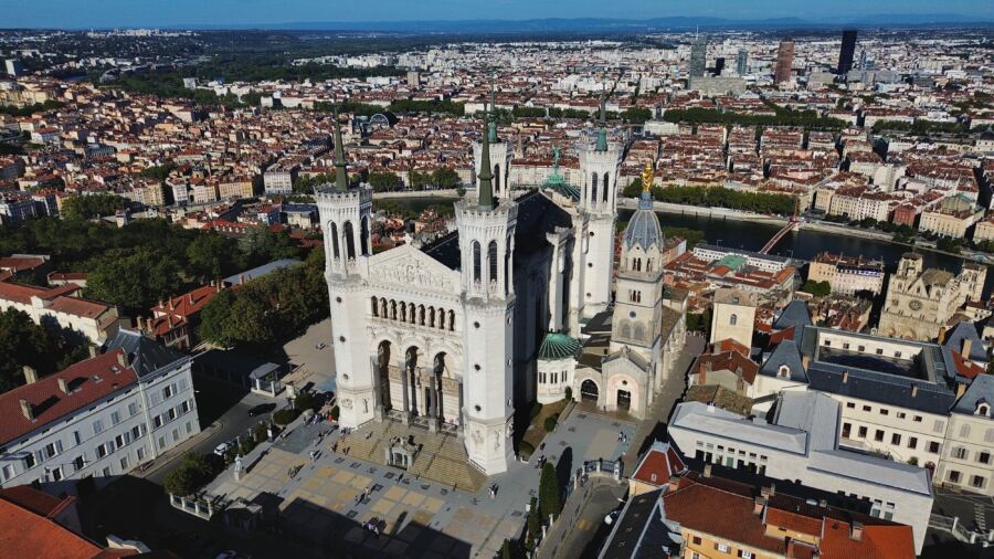 Aerial view of the Basilica of Notre-Dame de Fourvière in Lyon, France, showcasing its stunning architecture and surrounding landscape.