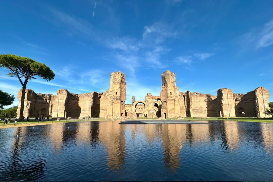 The Baths of Caracalla in Rome reflected beautifully on the calm water surface, showcasing their grand architecture