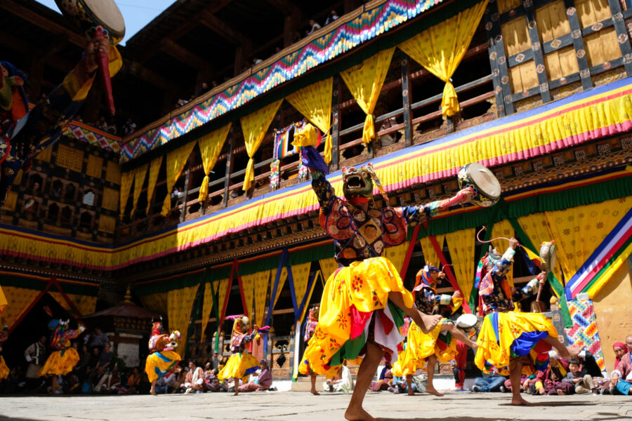 Colorful mask dancers perform at the Bhutan Tsechu festival in Paro Dzong, showcasing rich cultural traditions and heritage