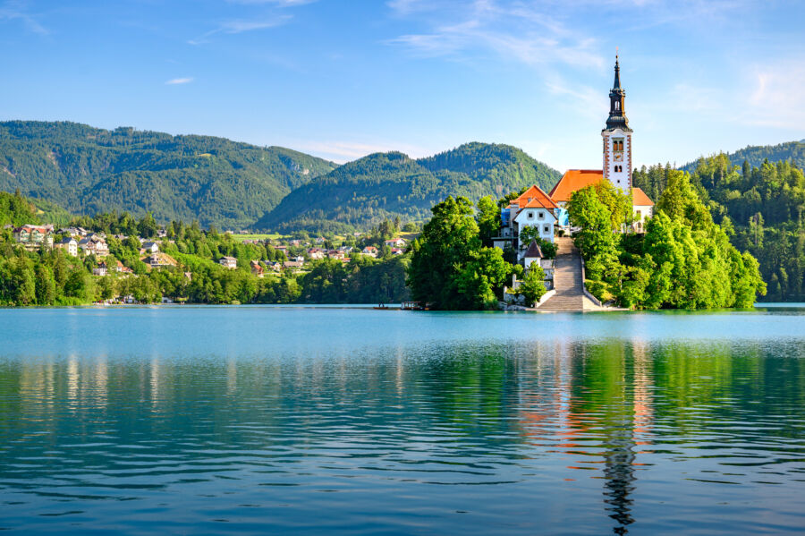 Panoramic view of the Pilgrimage Church on Lake Bled, Slovenia, showcasing its stunning architecture and surrounding landscape