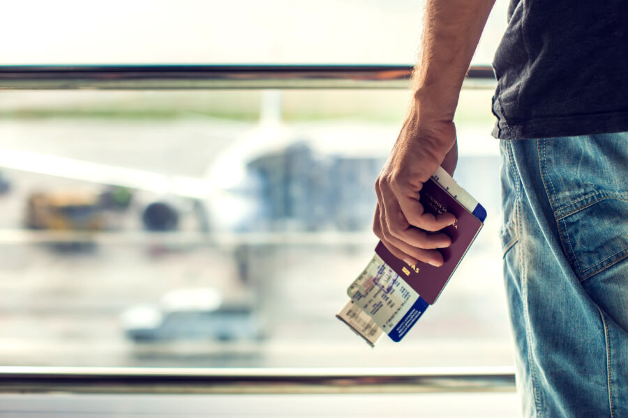 Closeup of a man holding passports and a boarding pass