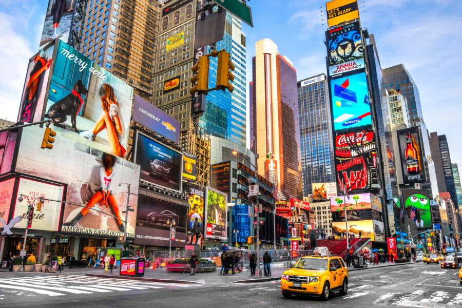 Lively scene of Times Square, featuring iconic Broadway theaters and dynamic LED signs that light up the surroundings