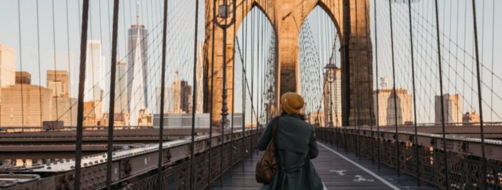 Lady walking on the Brooklyn bridge in NY during golden hour