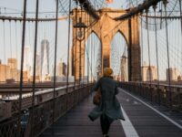 Lady walking on the Brooklyn bridge in NY during golden hour