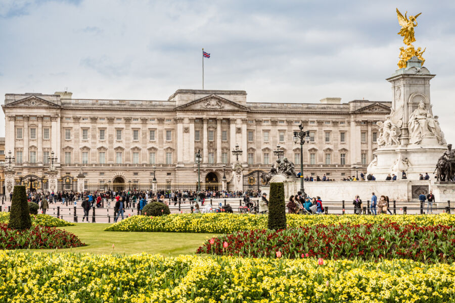 Panoramic view of Buckingham Palace in London, UK, highlighting its majestic structure and well-manicured gardens