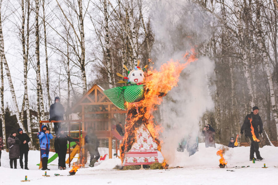 Effigy burning in snowy landscape; symbolizes winters end, springs arrival, cultural celebration.