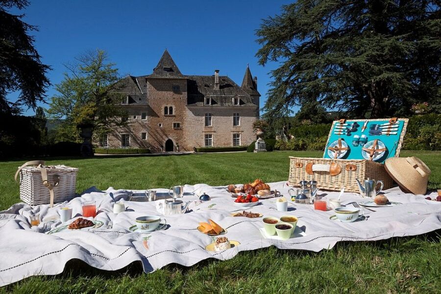 Picnic set and the building exterior of the Château de la Treyne