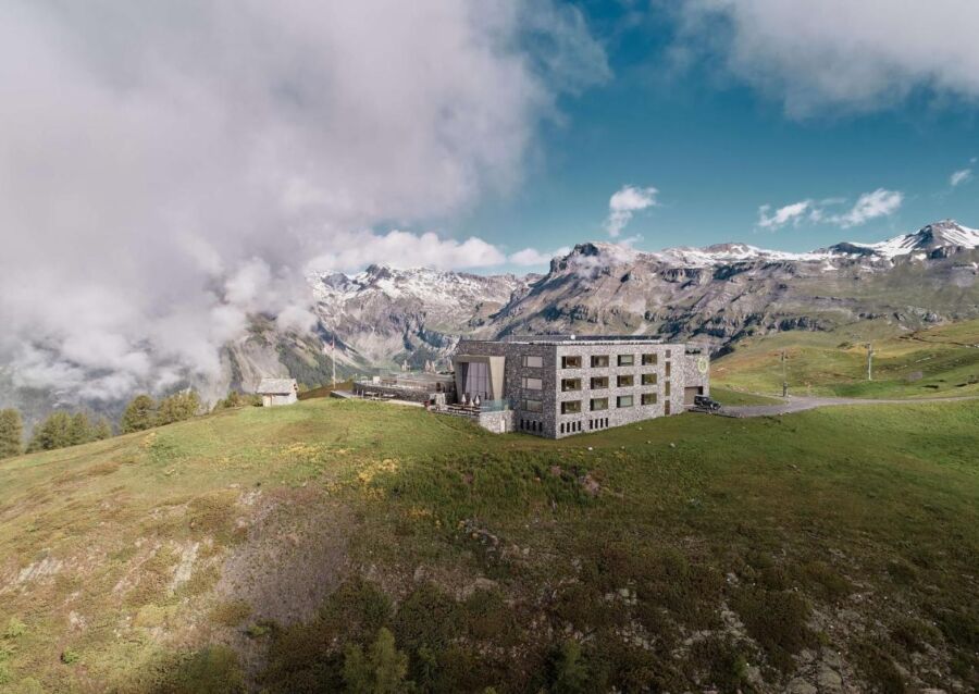 The exterior of Chetzeron in Switzerland, showcasing its modern architecture against a stunning mountain backdrop