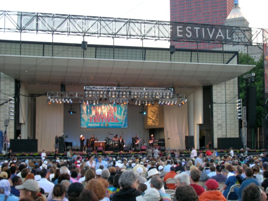 The Blues Festival stage bustling with activity, with a lively audience gathered as dusk begins to settle.
