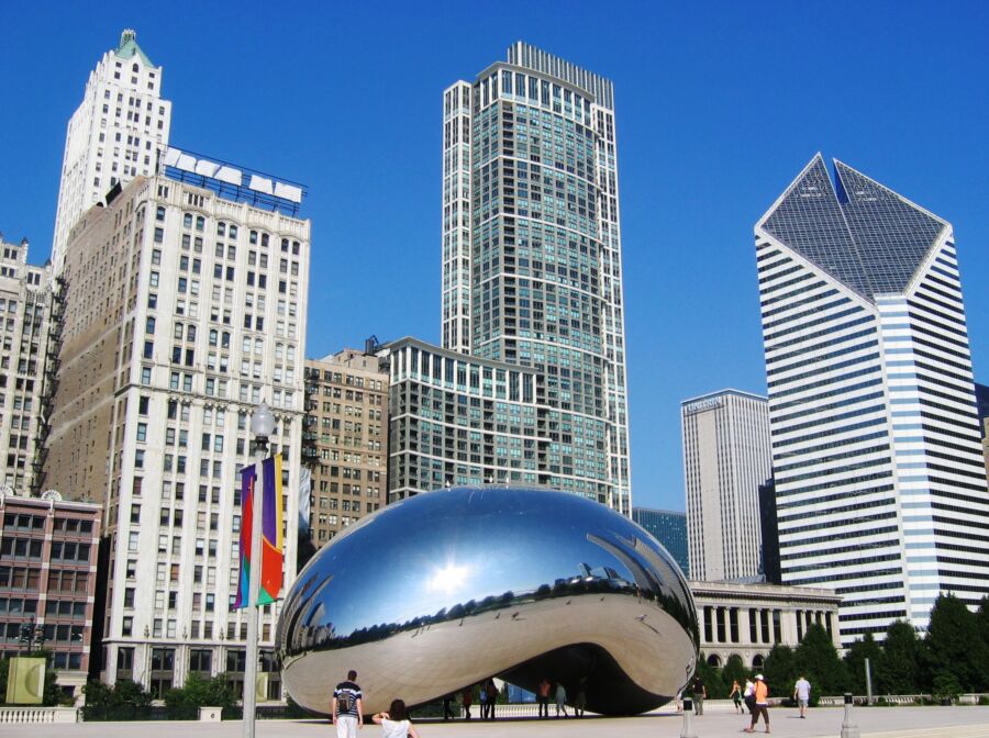 Scenic view of the Chicago Bean with iconic architecture lining the waterfront, showcasing the city's vibrant skyline