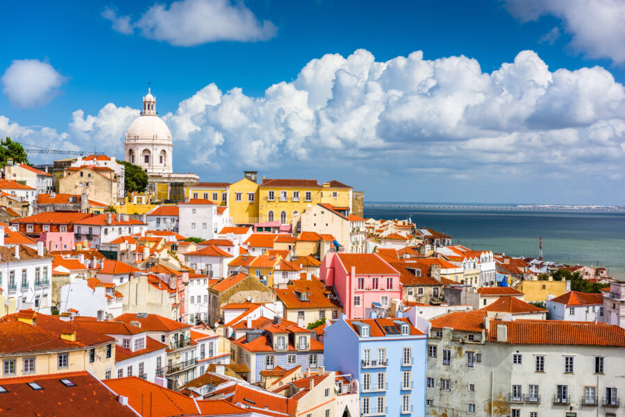 The picturesque skyline of Lisbon, Portugal, featuring historic architecture and colorful rooftops against a bright backdrop