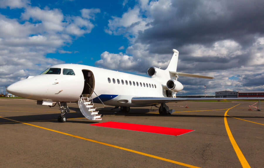 Close-up of a private jet's ladder and red carpet, emphasizing the luxurious experience of flying privately