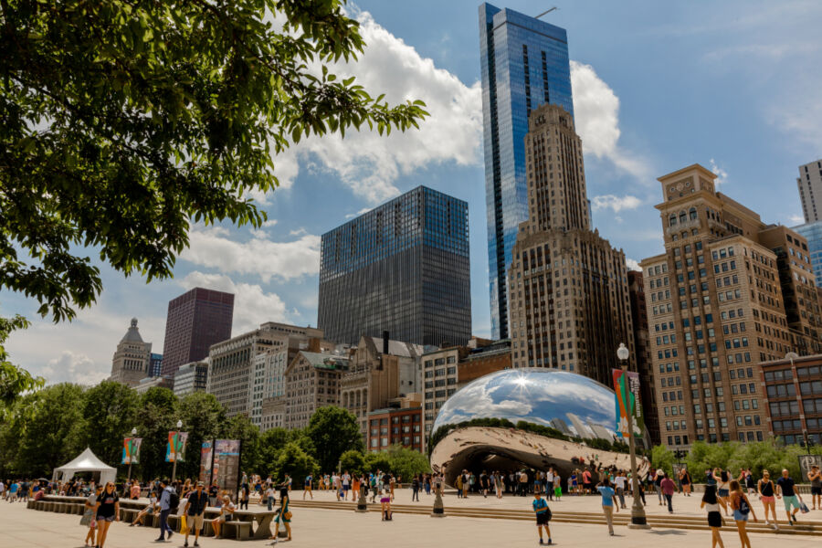 Cloud Gate Sculpture in Chicago, Illinois, with tourists and locals admiring its reflective surface and unique design