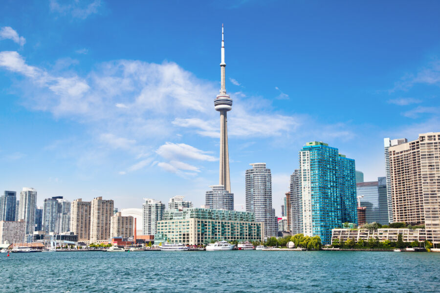 The cityscape of downtown Toronto showcases the CN Tower, beautifully reflecting on the waters of Lake Ontario