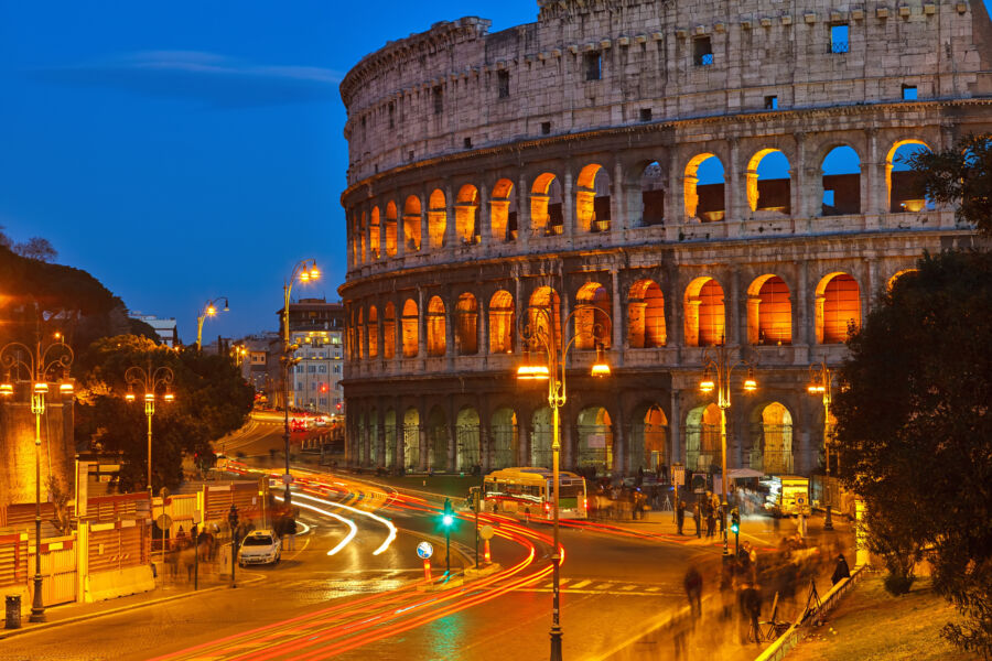 Night view of the Colosseum in Rome, illuminated against a dark sky