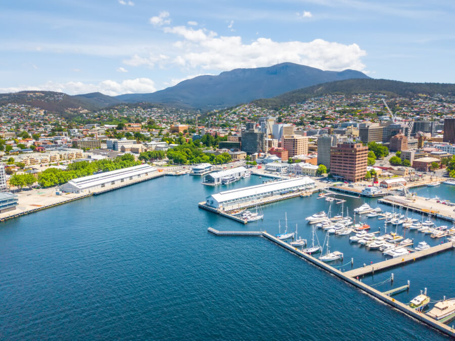 Aerial view of Constitution Dock in Hobart, Tasmania, showcasing boats and vibrant waterfront on a sunny day.