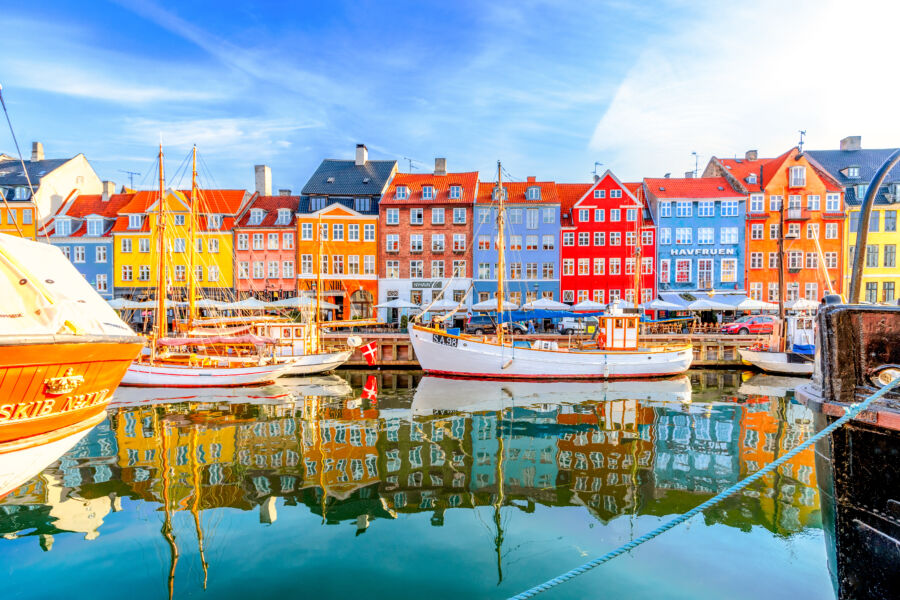 Scenic Nyhavn pier is lined with colorful buildings and boats, reflecting the charm of Copenhagen's historic Old Town