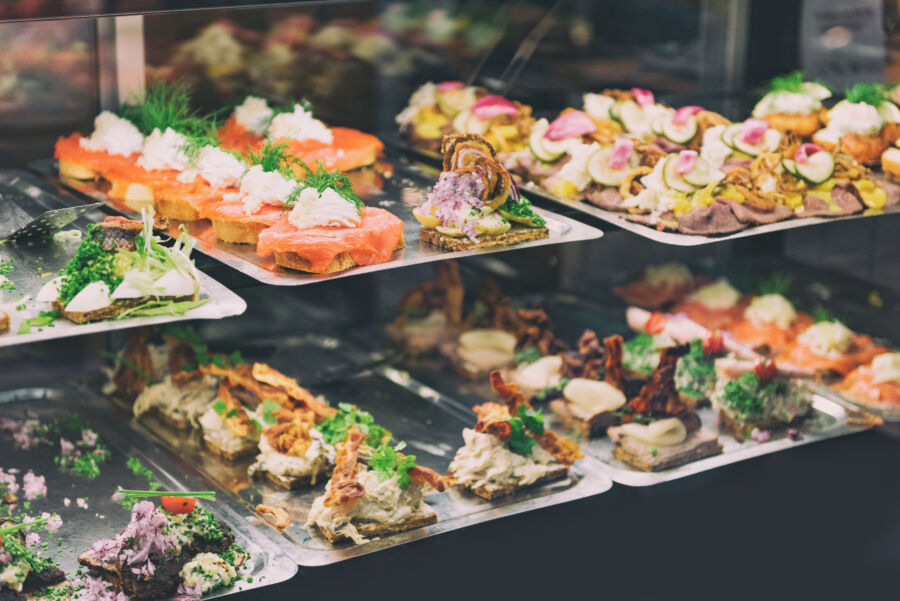 Traditional Danish Smørrebrød sandwich displayed at a food market in Copenhagen, showcasing vibrant toppings and fresh ingredients