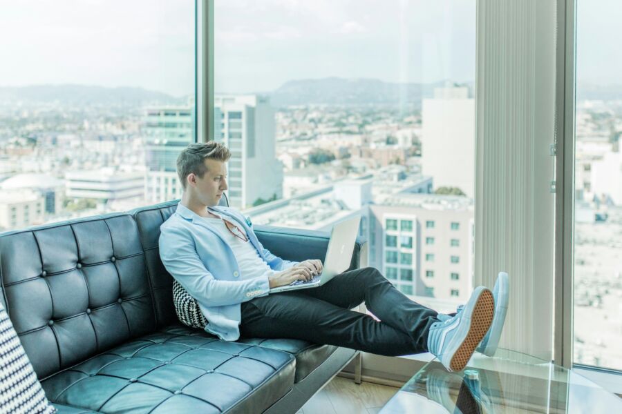 Digital nomad working on a sofa at a hotel lobby