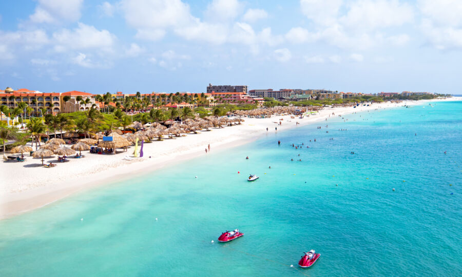 Aerial view of Eagle Beach in Aruba, showcasing its pristine white sands and turquoise waters under a clear blue sky