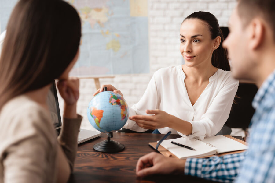 Young couple engages in conversation with a travel agent at a travel agency