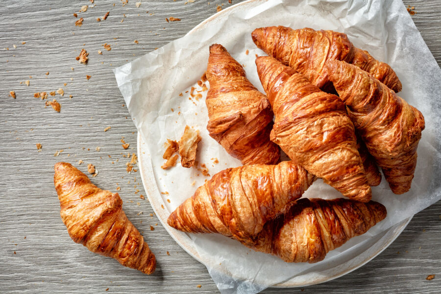 Platter of warm, freshly baked croissants, highlighting their buttery sheen and delicate, flaky crust