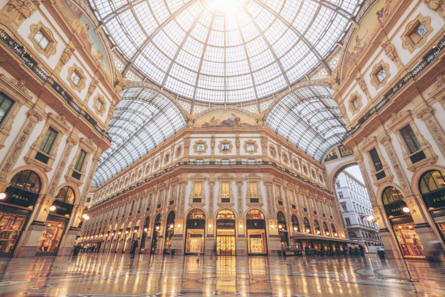 Interior view of Galleria Vittorio Emanuele II in Milan, showcasing its stunning roof and elegant shops.