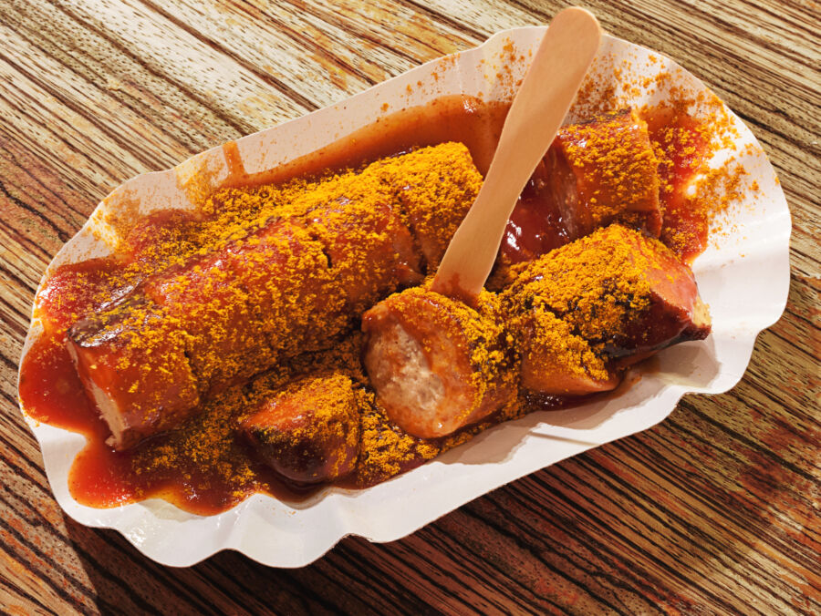 Serving of traditional German currywurst presented on a disposable plate