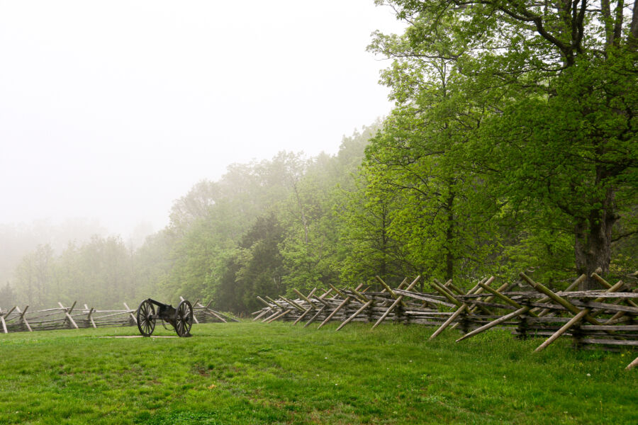 Historic cannon in a foggy field at Gettysburg, Pennsylvania, capturing the serene atmosphere