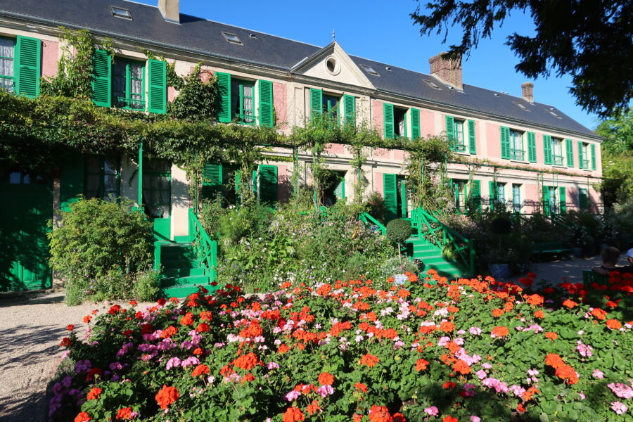 The charming facade of Claude Monet's house in Giverny, France, showcasing its beautiful architecture and vibrant garden