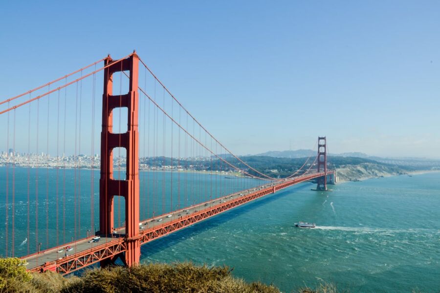 Golden Gate Bridge spanning San Francisco Bay, iconic landmark, vibrant orange against blue waters.