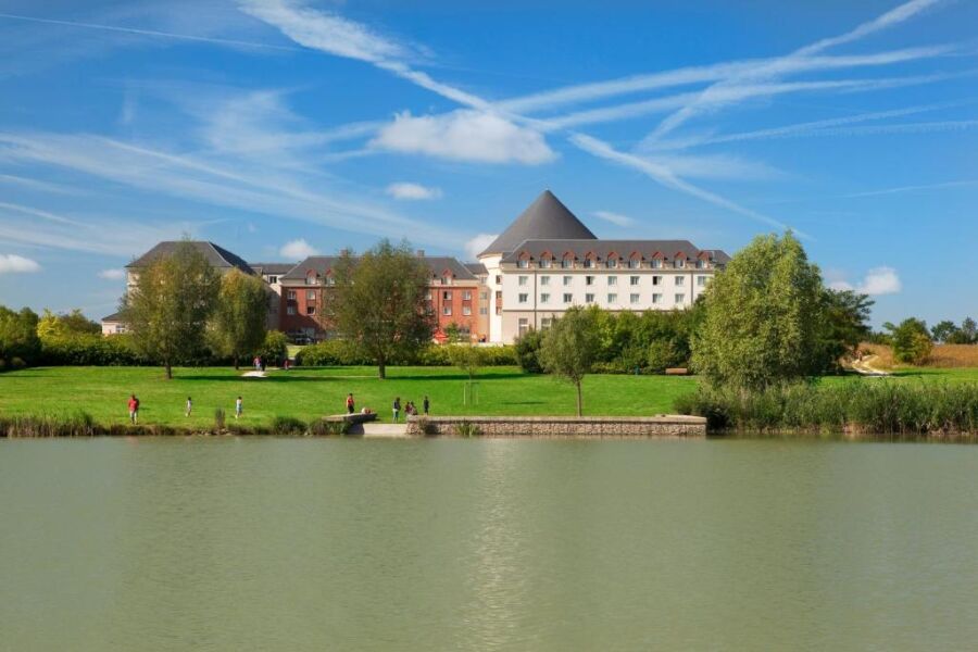 Panoramic view of the Grand Magic Hotel in Marne La Vallée, showcasing its colorful exterior and surrounding landscape.