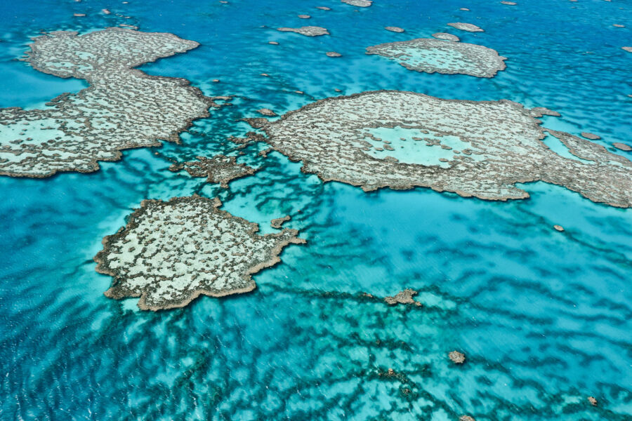 Aerial view of the Great Barrier Reef, showcasing vibrant coral formations and clear blue waters in Queensland, Australia