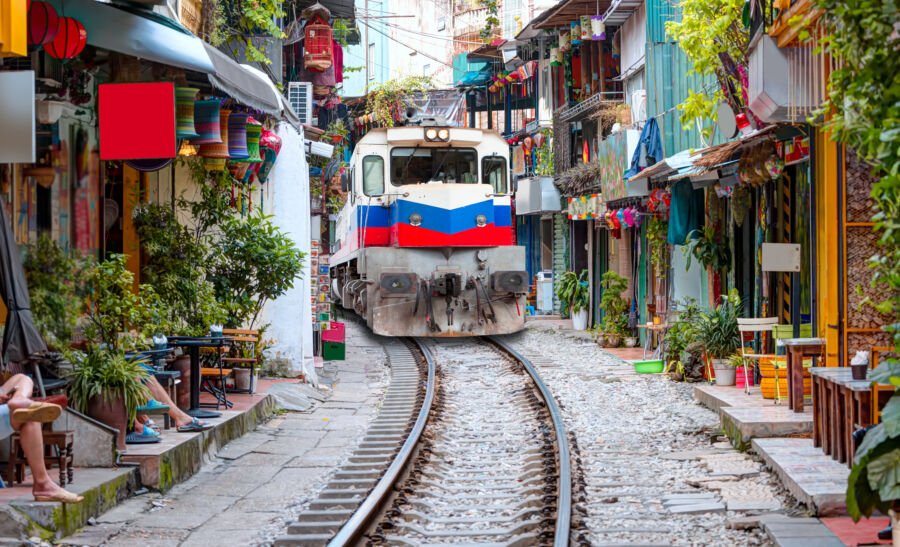 View of Hanoi's city railway running alongside narrow streets and houses in Vietnam, showcasing urban life