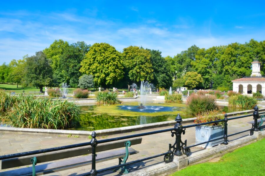 Charming fountain in Hyde Park, London, with lush foliage and visitors appreciating the calm and beauty of the scene