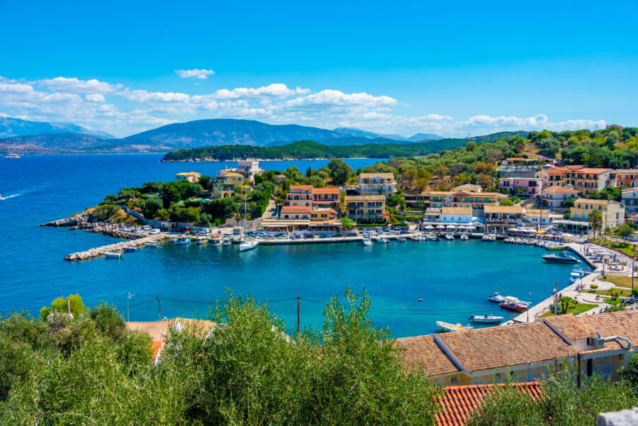 Scenic panorama of Kassiopi port in Corfu, Greece, highlighting the vibrant coastal scenery and tranquil waters