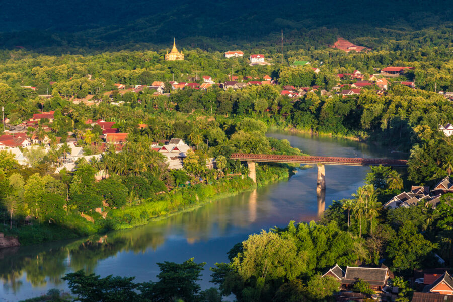 Panoramic view of Luang Prabang, Laos, featuring the cityscape along the Khan River, framed by verdant hills