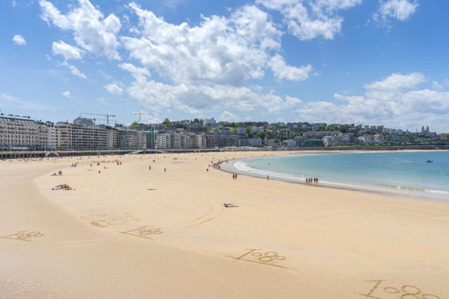 Beautiful summer day at La Concha beach in San Sebastian, Spain, showcasing its fine sandy shores