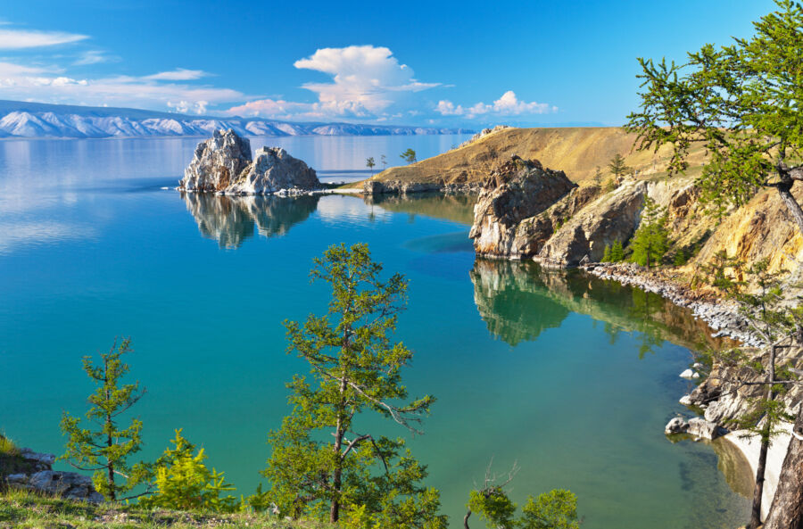 Scenic view of Lake Baikal with Olkhon Island in the summer, showcasing lush greenery and tranquil waters