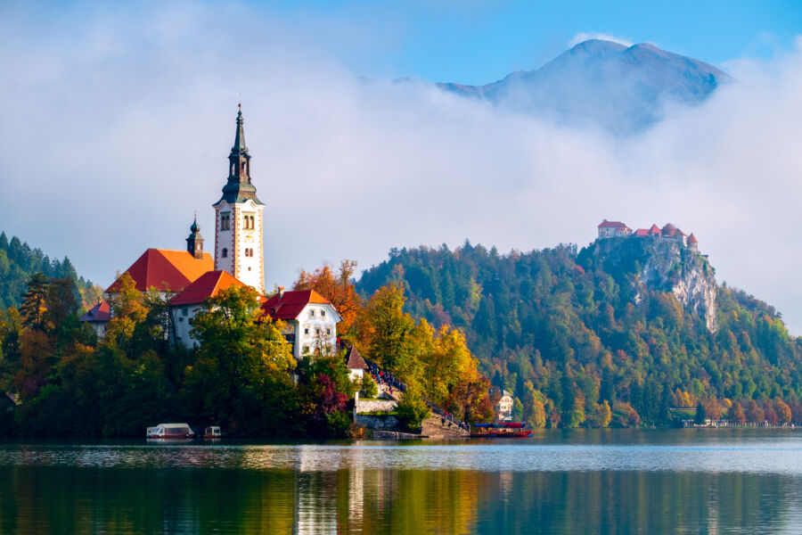 Panoramic view of Lake Bled, showcasing its emerald waters, island church, and surrounding mountains in Slovenia